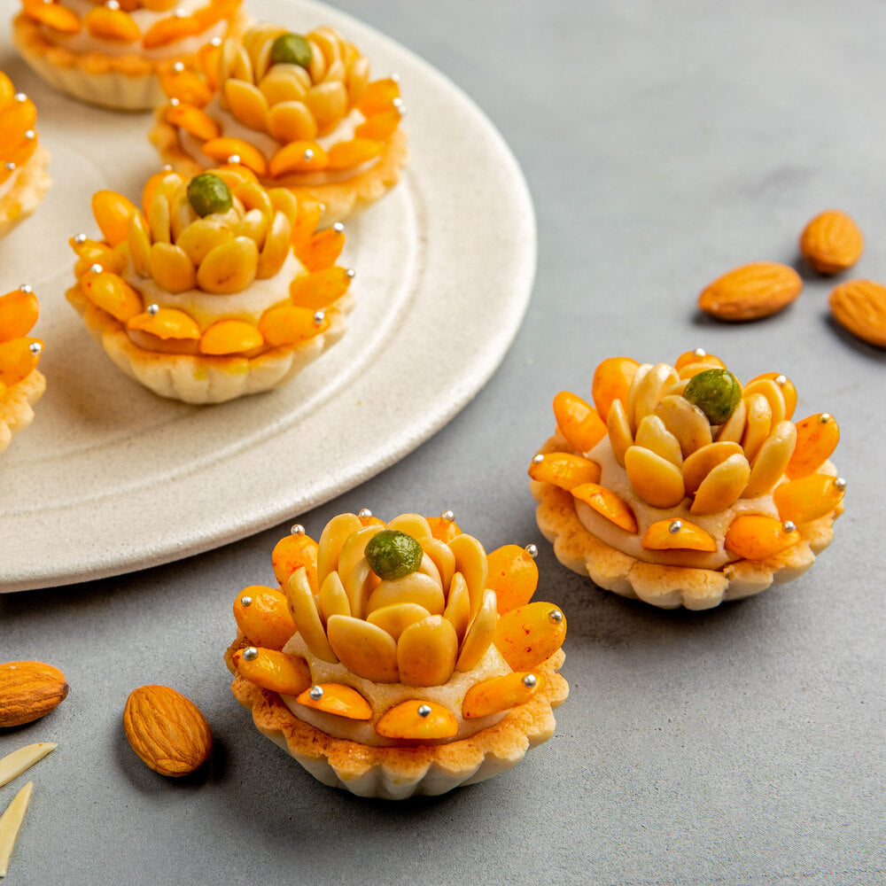 Almond tart stuffed with Mamra Badam Barfi and adorned with almond pieces in the form of a flower