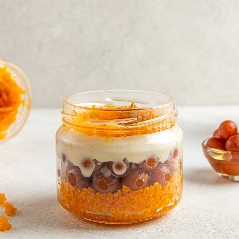 Elegantly layered jar with boondi, mini gulab jamuns, and rich rabdi, creating a visually appealing dessert presentation.