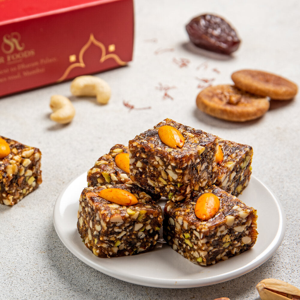 Beautifully crafted dates dryfruit barfi pieces, each decorated with an almond piece.