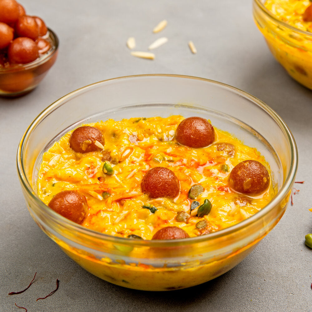Kesaria Rabdi in a bowl with mini gulab jamuns and slivers of dry fruit