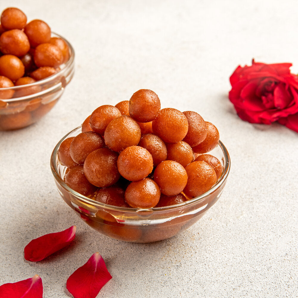Bite sized gulab jamuns sitting in a bowl.