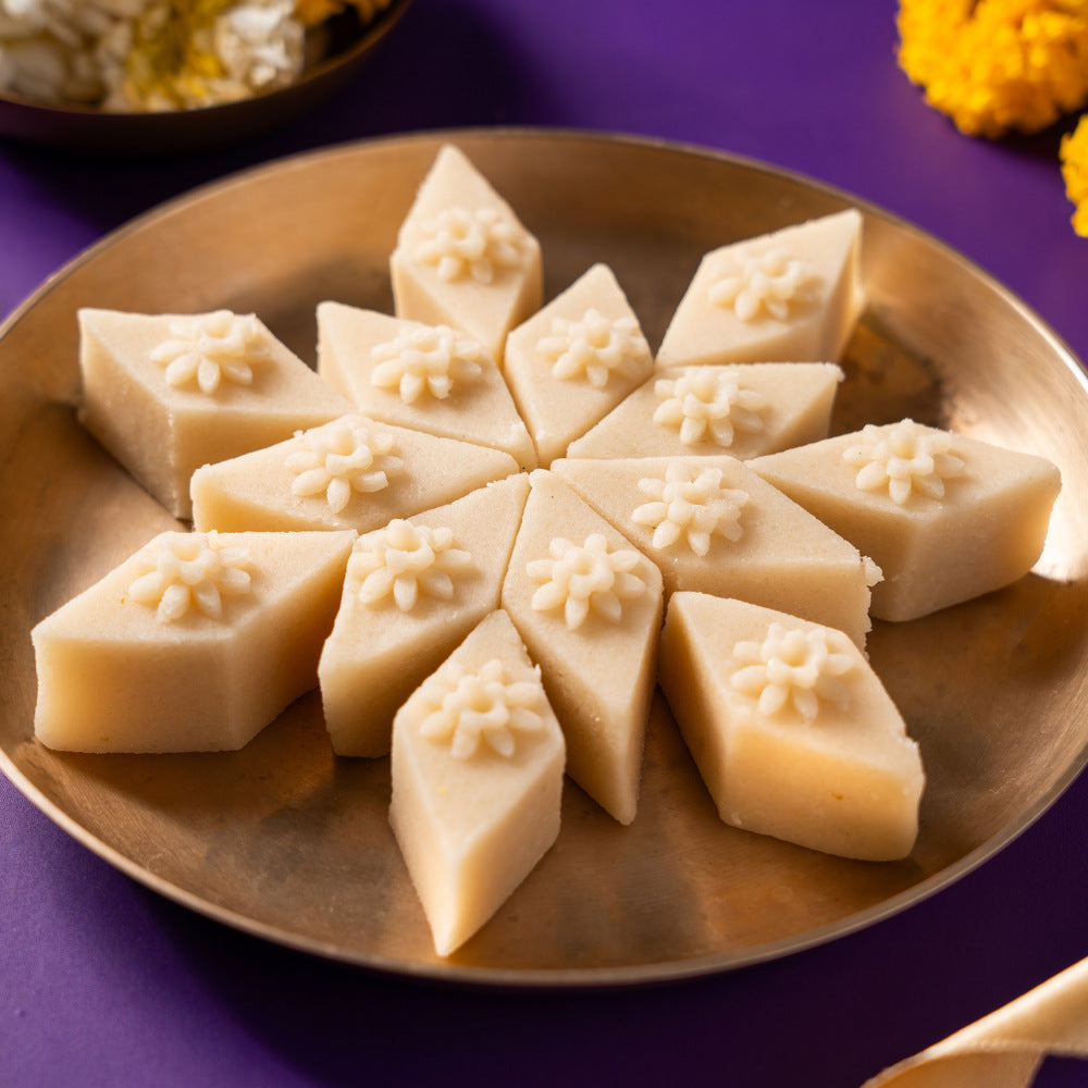 Beautifully crafted mini mamra badam barfi in the shape of a katli with floral decoration