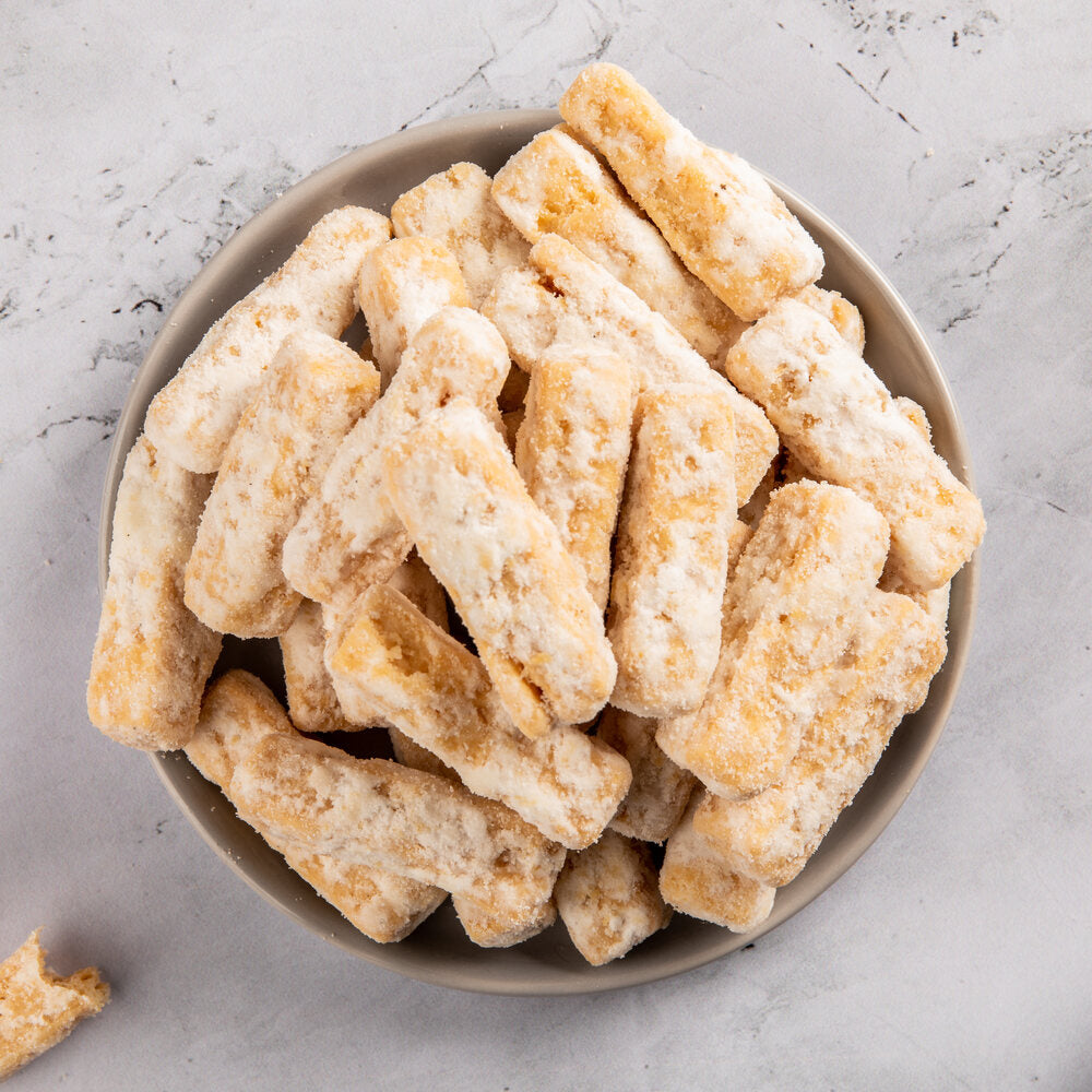 Plate of shakarpara sticks coated with sugar, perfect for snacking